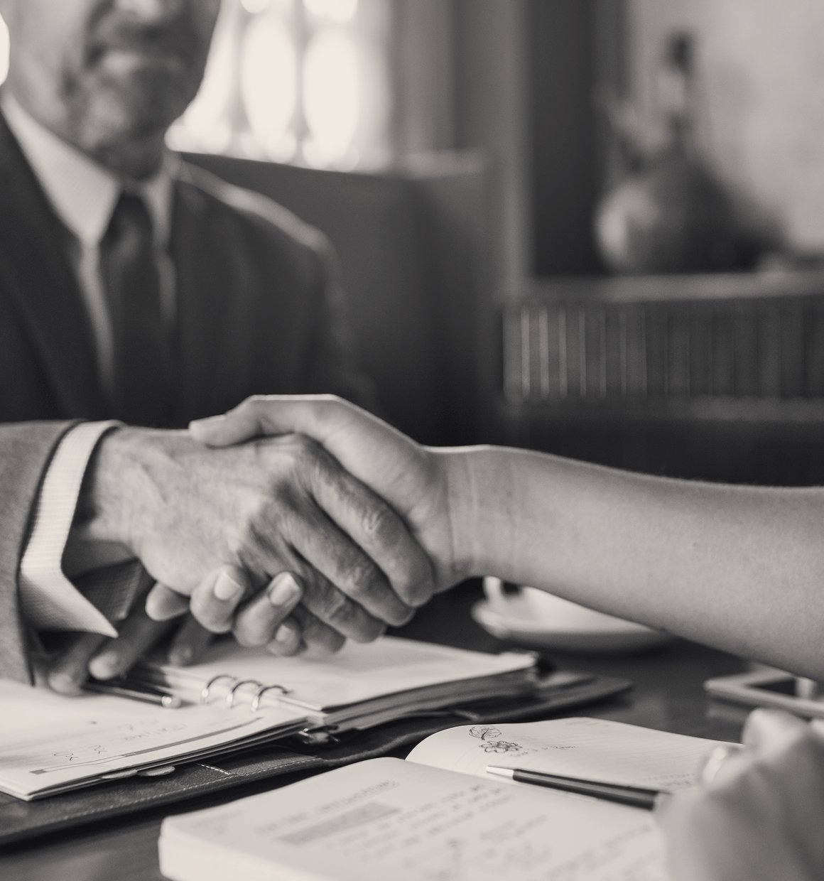 Attorney shaking hands with a client during a consultation